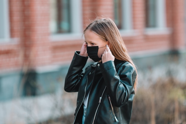 La ragazza che indossa una maschera protegge dal Coronavirus