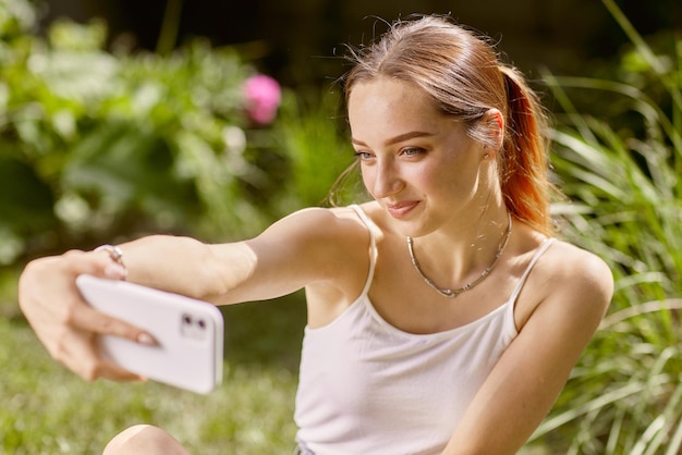 La ragazza comunica online al telefono in natura chat online in natura