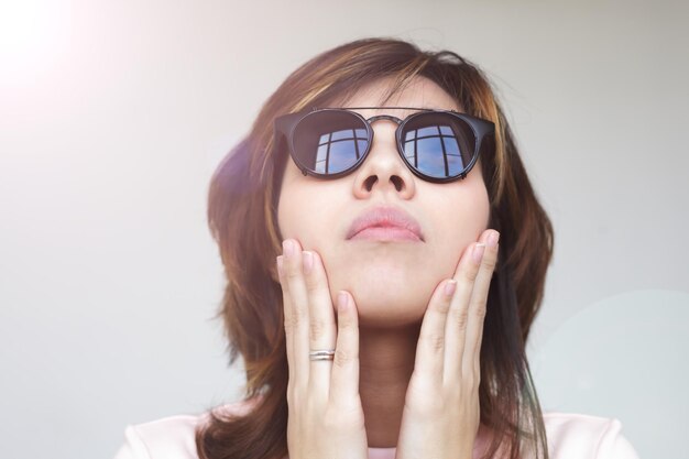 La ragazza con gli occhi solari che guarda le mani in faccia