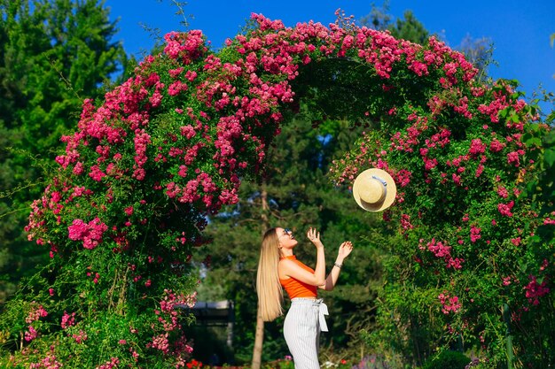 La ragazza con i capelli lunghi lancia una paglietta vicino al bellissimo arco con il rosa