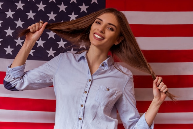 La ragazza con la bandiera americana tira le rughe.