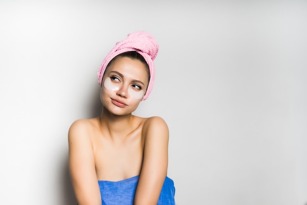 La ragazza con un asciugamano in testa distoglie lo sguardo pensierosa