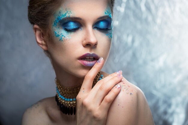 La ragazza con un trucco alla moda brillante e scintillii