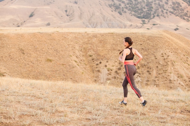 La ragazza corre in montagna sull'oceano.