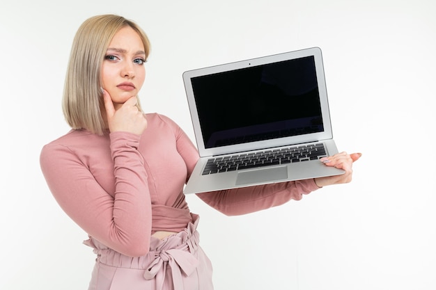 La ragazza dai capelli corti con i capelli bianchi mostra uno schermo portatile con uno spazio vuoto su uno sfondo bianco studio