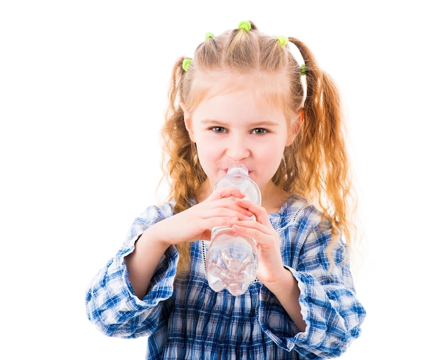 La ragazza del bambino beve l'acqua minerale dalla bottiglia