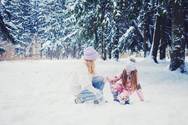 La ragazza del bambino e della madre sull'inverno nevoso cammina in natura