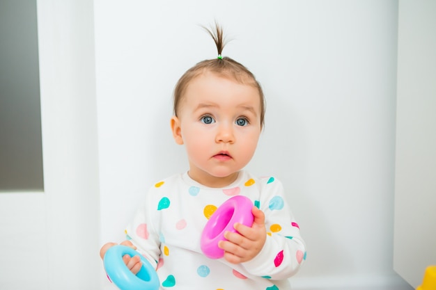 La ragazza del bambino gioca giochi educativi a casa. Il bambino si siede sul pavimento della casa