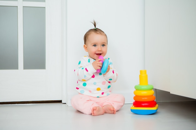 La ragazza del bambino gioca giochi educativi a casa. Il bambino si siede sul pavimento della casa