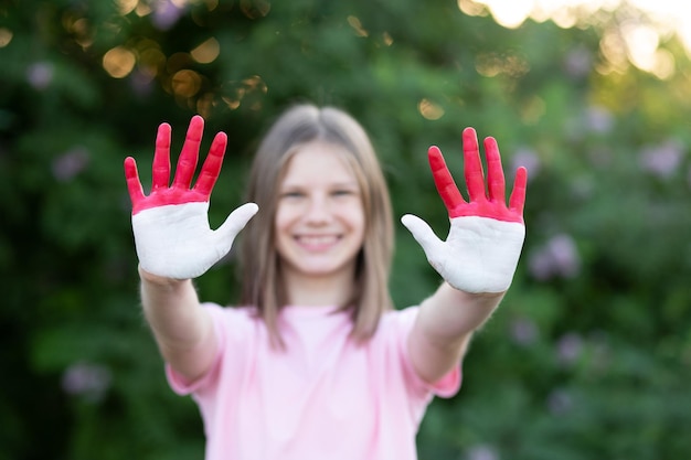 La ragazza del bambino mostra le mani dipinte nei colori della bandiera dell'indonesia si concentrano sulle mani il concetto di patriottismo indonesiano ...