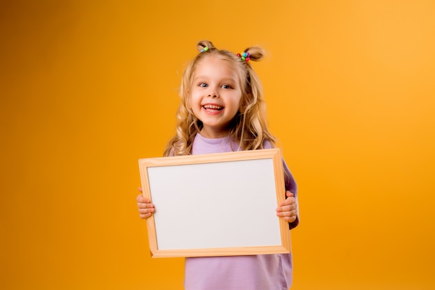 La ragazza del bambino tiene un tavolo da disegno vuoto bianco in sue mani