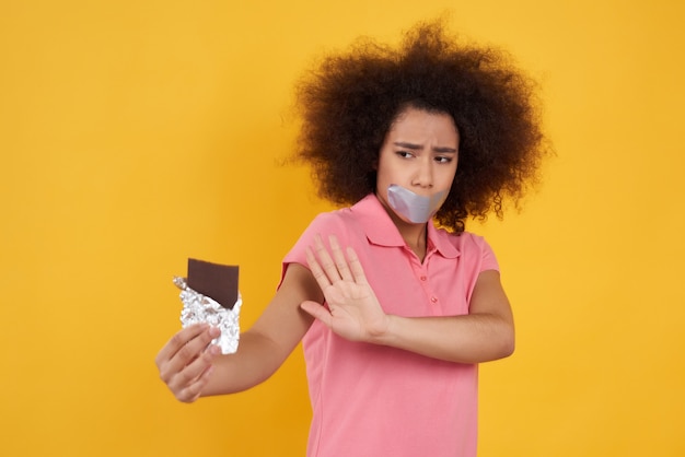 La ragazza dell&#39;afroamericano non può mangiare il cioccolato isolato