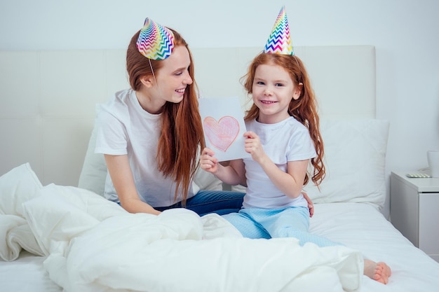 La ragazza della festa della mamma regala una cartolina a sua madre