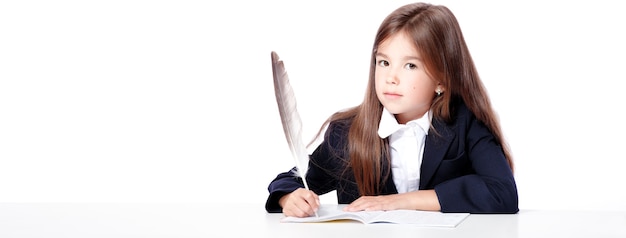 La ragazza della scuola adolescente felice e carina scrive in un libro o in un taccuino