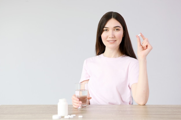 La ragazza di buon umore prende le pillole a casa