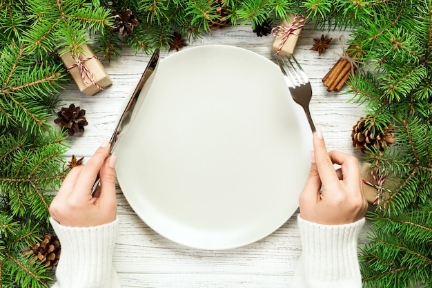 La ragazza di vista superiore tiene in mano forchetta e coltello ed è pronta da mangiare,