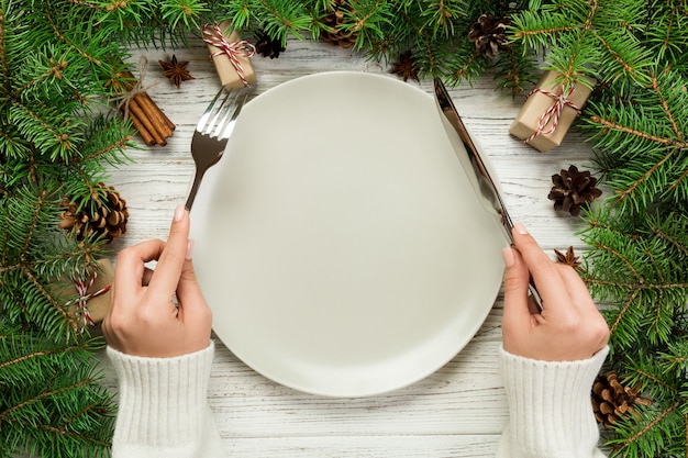 La ragazza di vista superiore tiene in mano forchetta e coltello ed è pronta da mangiare,