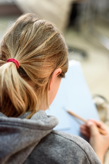 La ragazza disegna una matita nell'albumview dal primo piano posteriore