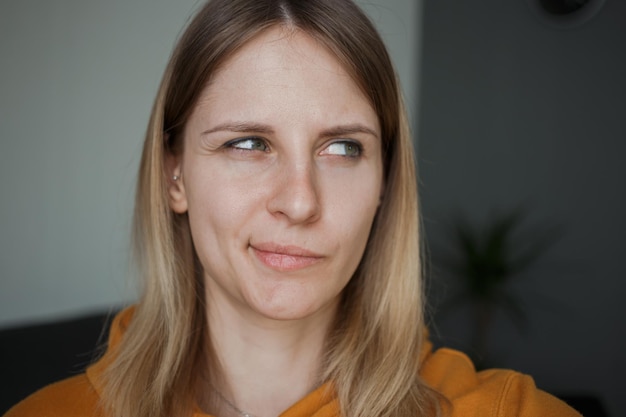 La ragazza distoglie lo sguardo strizzando gli occhi