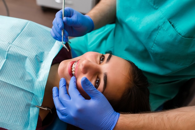 La ragazza è alla reception dal dentista. Un cliente felice dal dentista sorride.