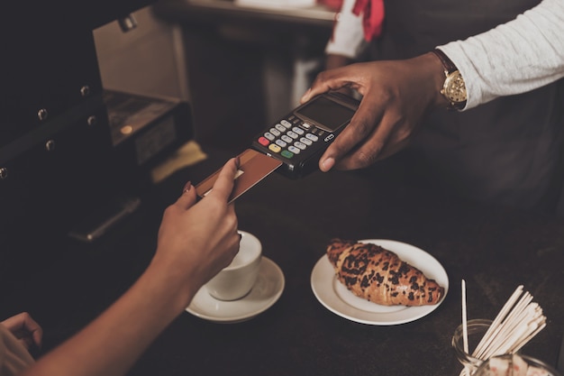 La ragazza è calcolata il caffè con carta di credito