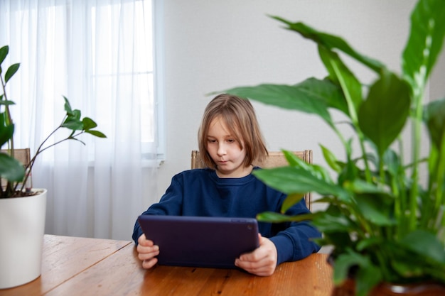 La ragazza è fidanzata su un tablet al tavolo