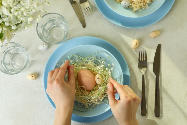 La ragazza fa la regolazione della tavola di Pasqua felice, vista dall'alto