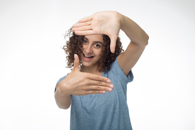 La ragazza fa selfie cornice per foto dalle mani.