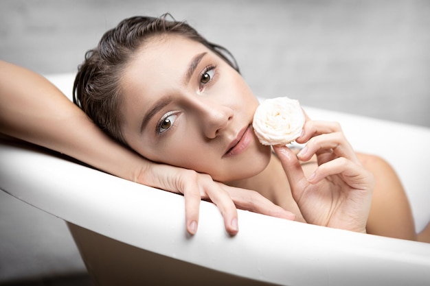 La ragazza fa un bagno curando il suo corpo e la pelle spa e aromaterapia