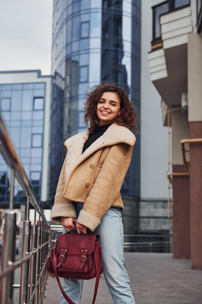 La ragazza fa una passeggiata all'aperto nella città vicino all'edificio degli affari