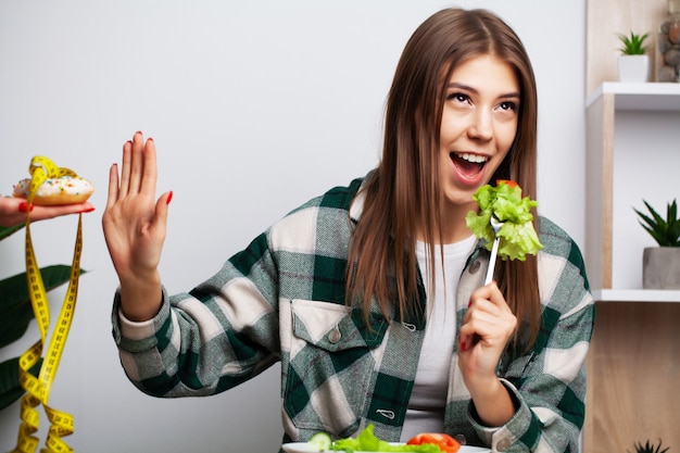 La ragazza fa una scelta tra cibo sano e dannoso