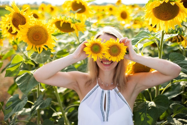 La ragazza felice ama passare il tempo in un campo con i girasoli