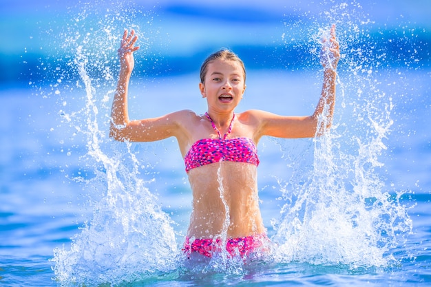 La ragazza felice del preteen gode dell'acqua estiva e delle vacanze in destinazioni di vacanza