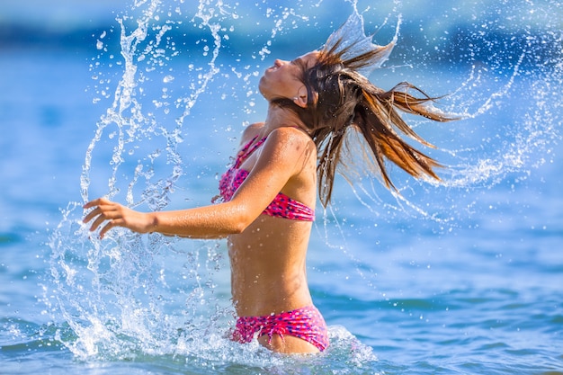 La ragazza felice del preteen gode dell'acqua estiva e delle vacanze in destinazioni di vacanza