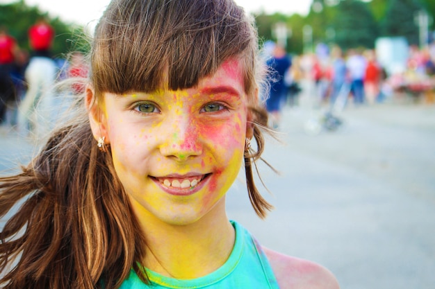 La ragazza felice mostra la classe con la pittura di holi.