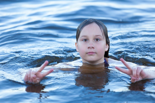 La ragazza felice nuota nell'acqua