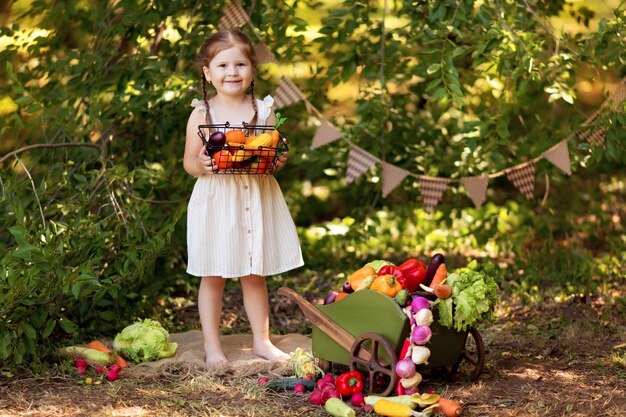 La ragazza felice prepara l'insalata di verdure in natura