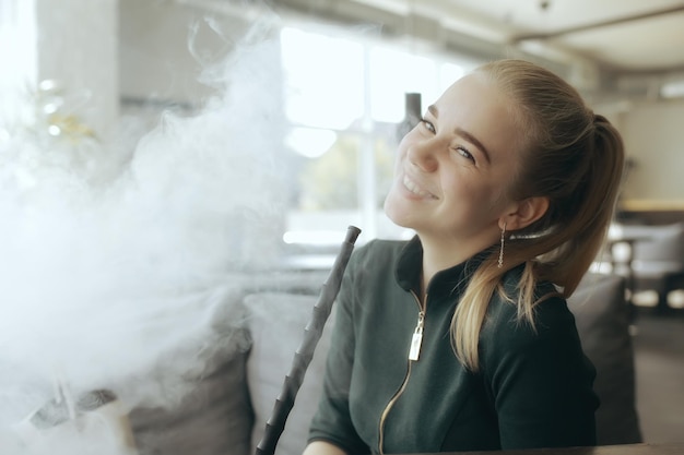 la ragazza fuma un narghilè al bar / fumo, salute, sigarette moderne vape