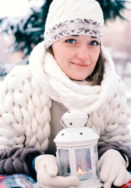 La ragazza giace sulla neve nella foresta invernale o nel parco Concetto Vacanze e vacanze di Natale