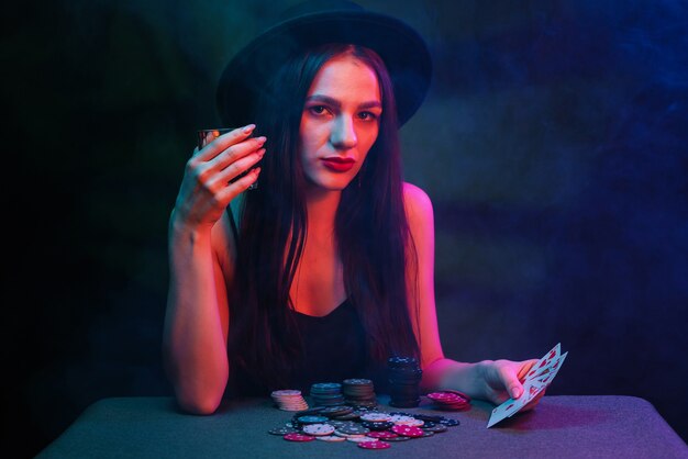 La ragazza gioca a poker a un tavolo con carte e fiches in un casinò. Concetto di gioco d'azzardo