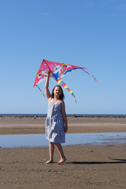 La ragazza gioca con un aquilone sul mare