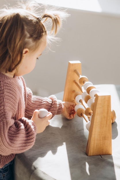 La ragazza gioca i giocattoli nel soggiorno Montessori giocattolo di legno piramide piegata Cerchio triangolo rettangolo elementi in legno di giocattoli per bambini giocattolo colorato blu giallo rosso verde