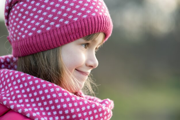 La ragazza graziosa del bambino nell'inverno tricottato caldo copre all'aperto.