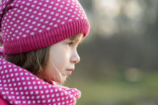 La ragazza graziosa del bambino nell'inverno tricottato caldo copre all'aperto.