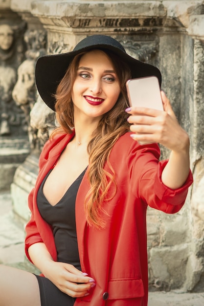 La ragazza graziosa del turista sta prendendo un selfie.