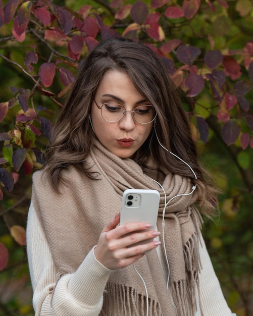 la ragazza guarda il telefono, controlla il suo account o legge un messaggio, emozioni sul suo viso, gioia, sorpresa