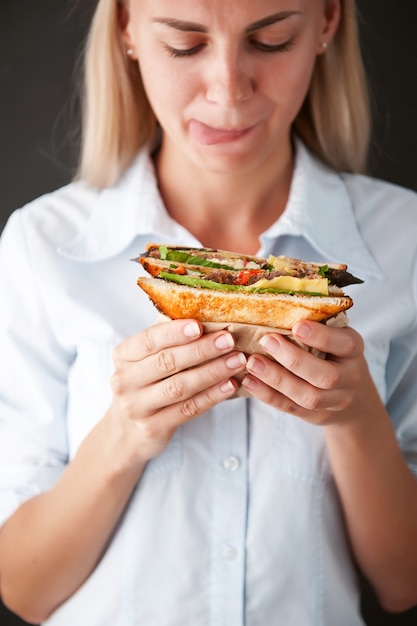 La ragazza guarda un delizioso panino