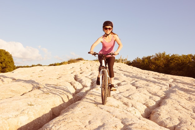 La ragazza guida la sua bici giù per la collina.