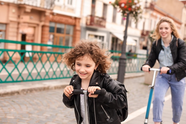 La ragazza guida per la prima volta uno scooter insieme alla mamma