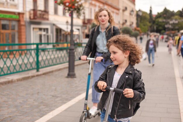 La ragazza guida per la prima volta uno scooter insieme alla mamma